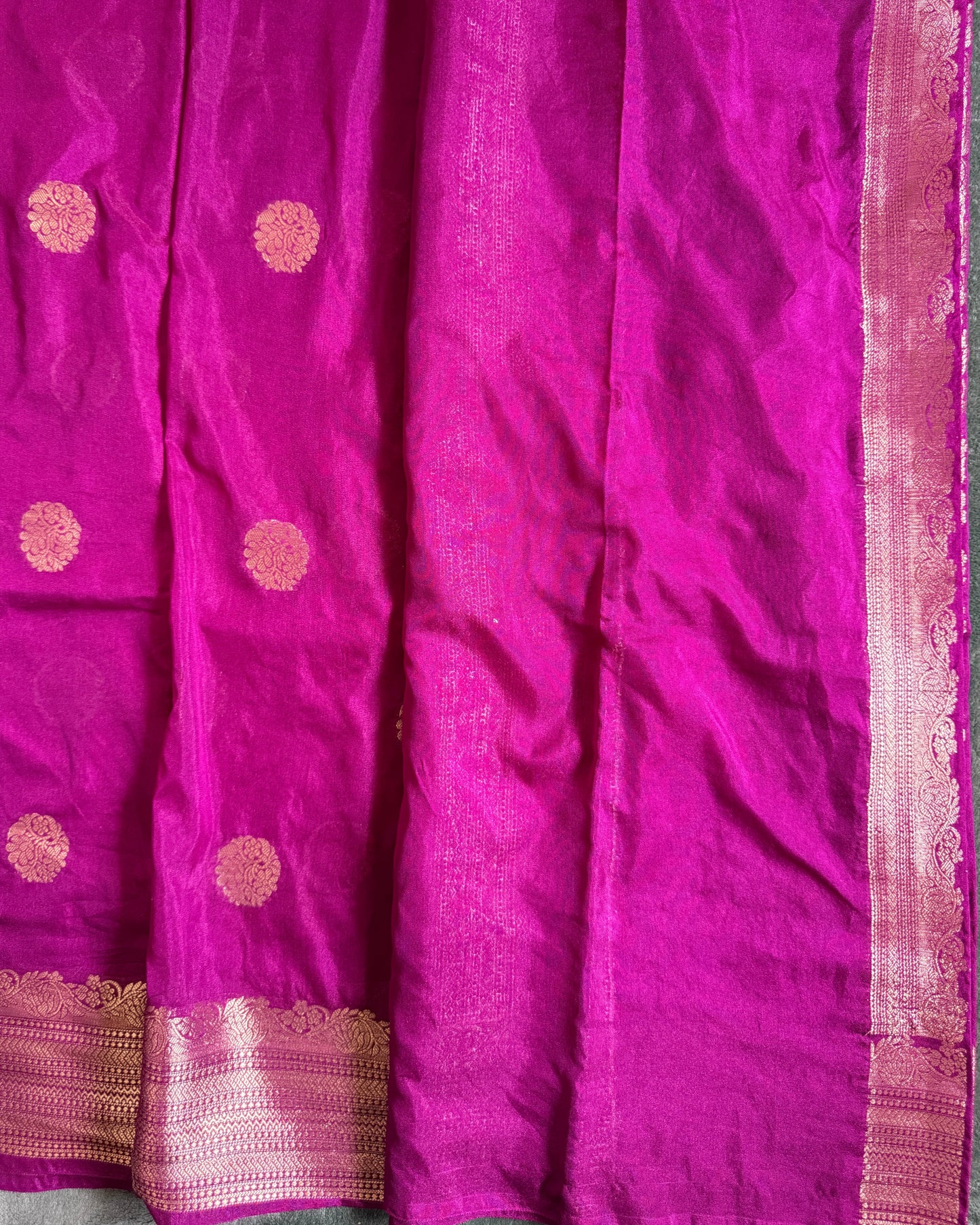 Purple fabric with gold circular patterns and a border