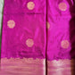 Purple fabric with gold circular patterns and a border on a textured surface