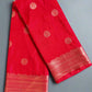 Red fabric with gold patterns on a gray surface