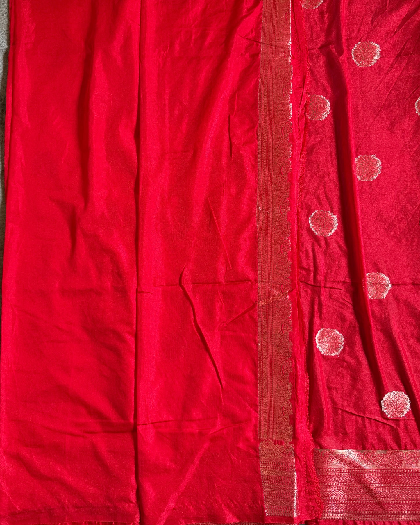 Red fabric with white dot patterns on a gray surface
