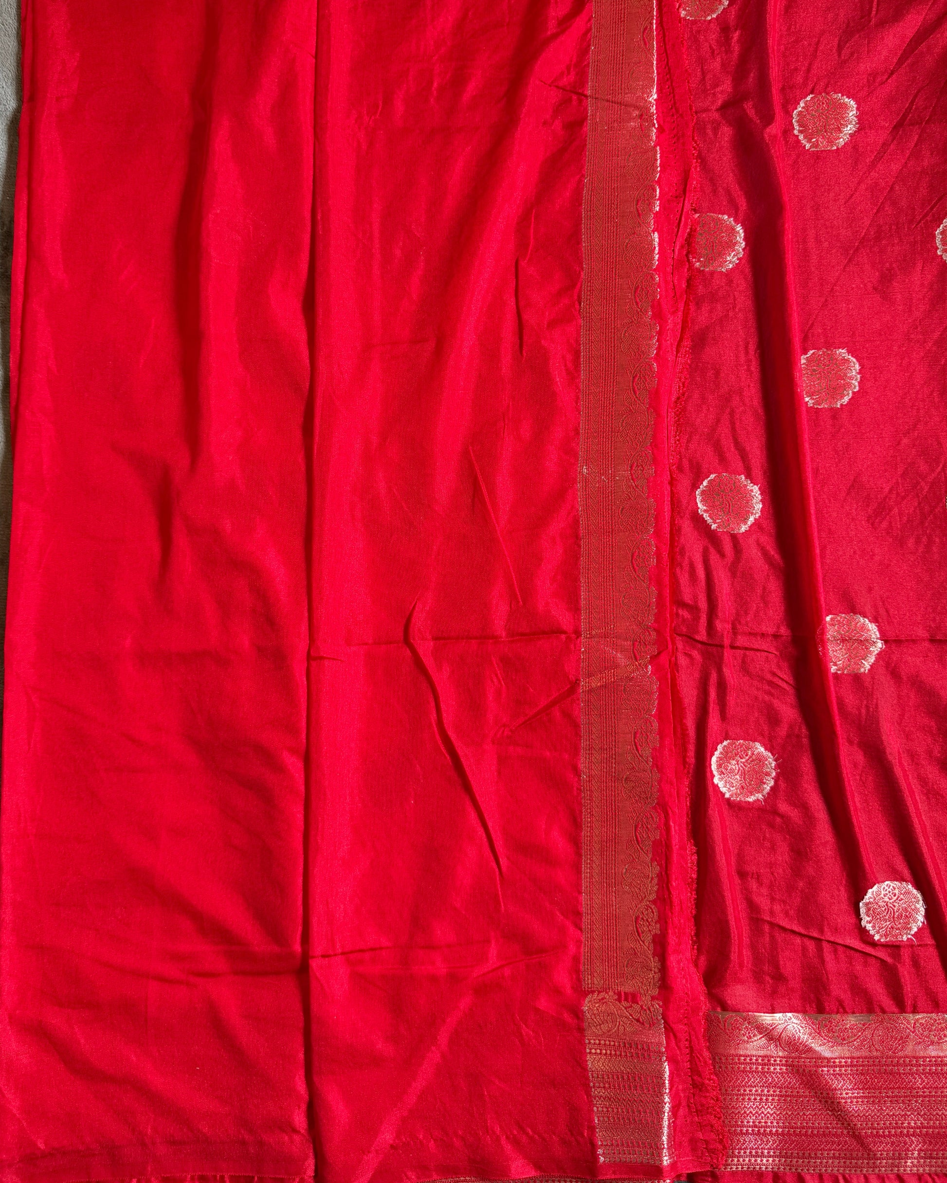 Red fabric with white dot patterns on a gray surface