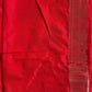 Close-up of a red fabric with intricate patterns and embroidery.