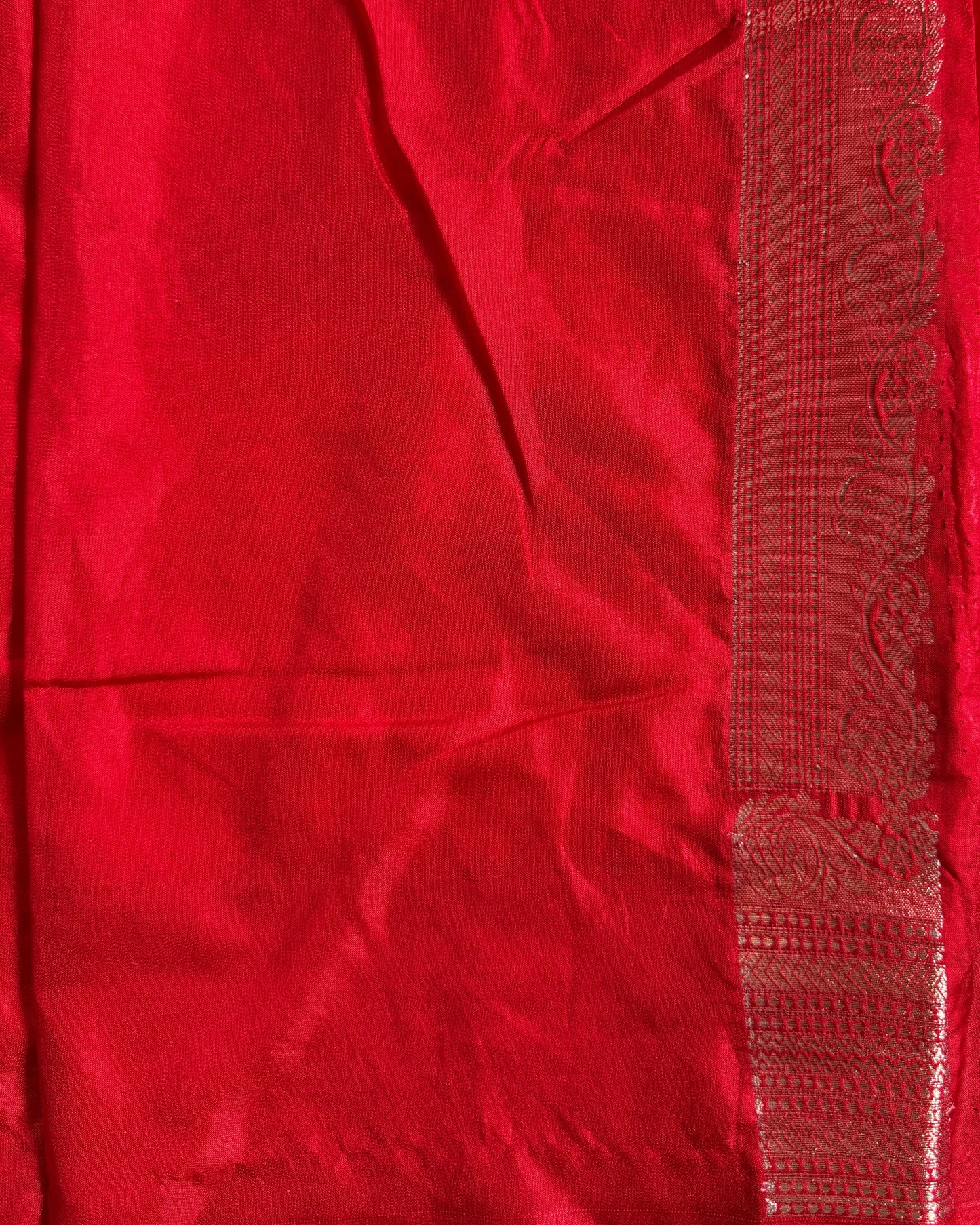 Close-up of a red fabric with intricate patterns and embroidery.