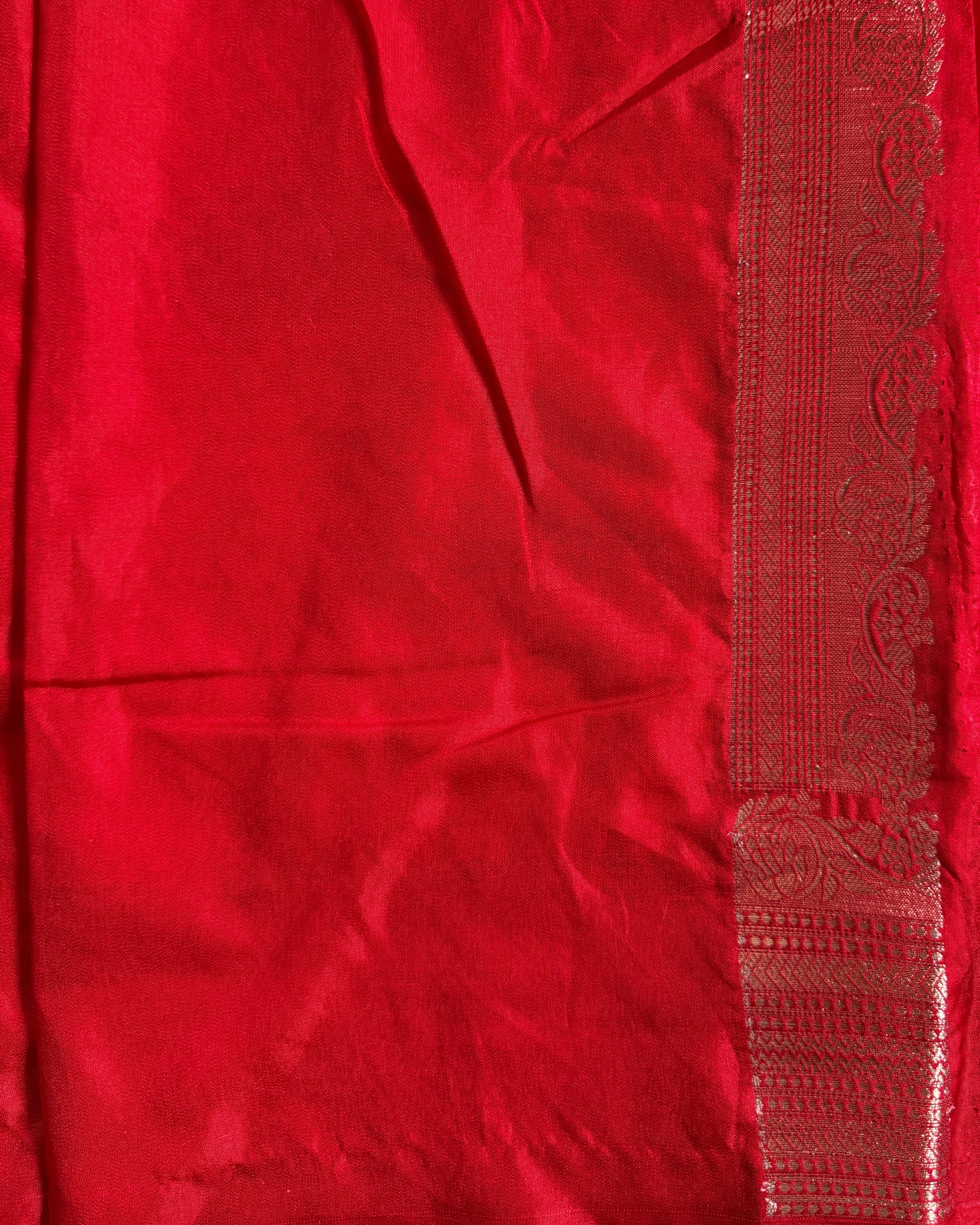 Close-up of a red fabric with intricate patterns and embroidery.