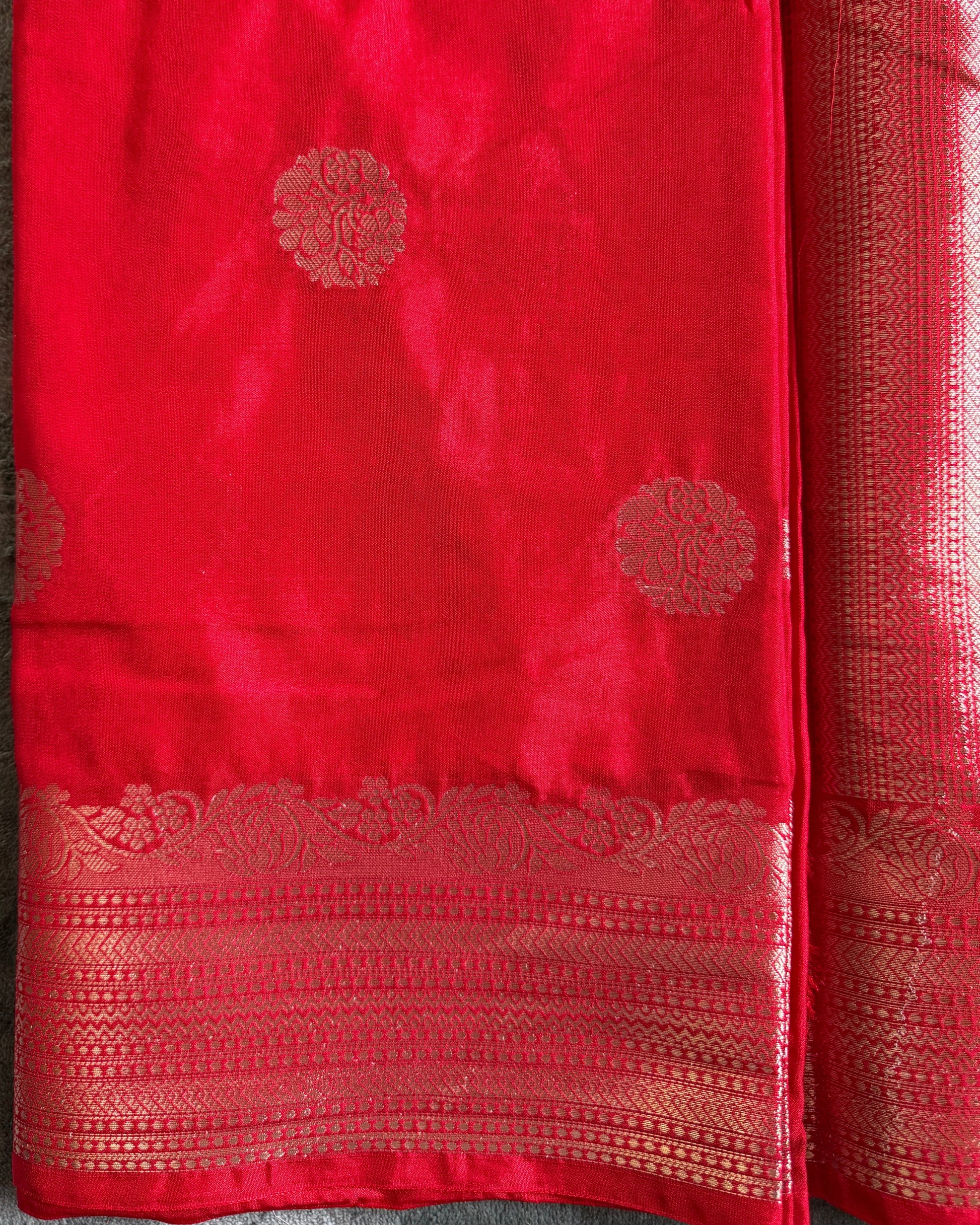 Red fabric with gold patterns on a gray surface
