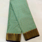 Light blue saree with gold and purple border on a white background