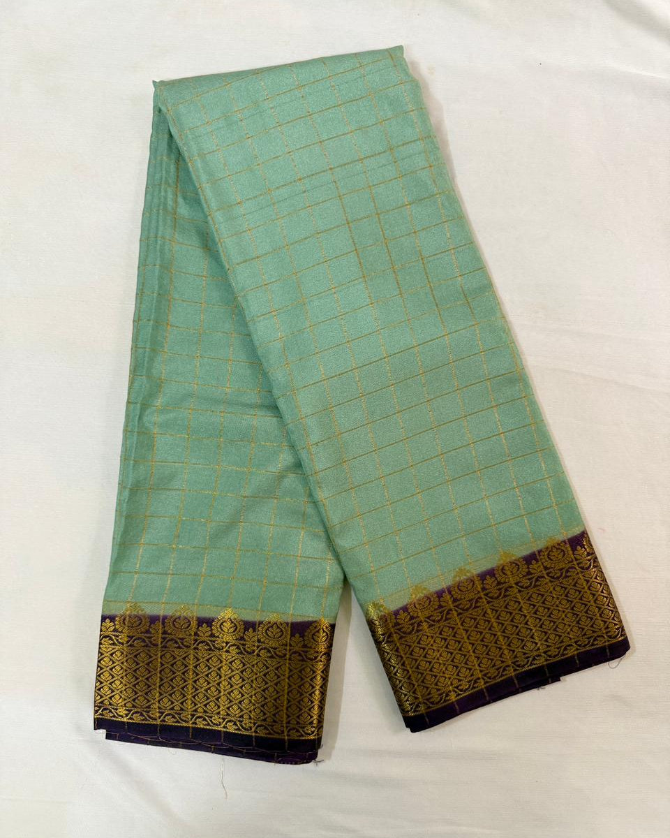 Light blue saree with gold and purple border on a white background