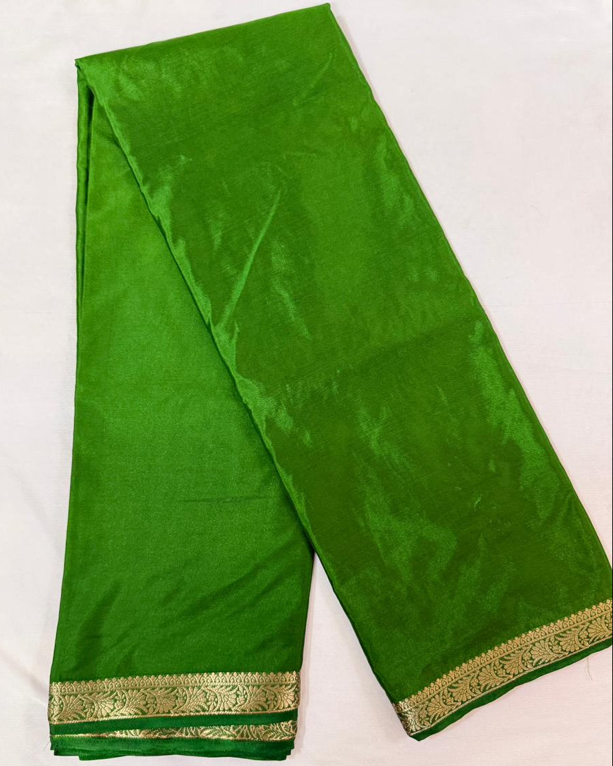 Green saree with gold border on a white background