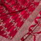 Red fabric with intricate gold and silver embroidery on a white background