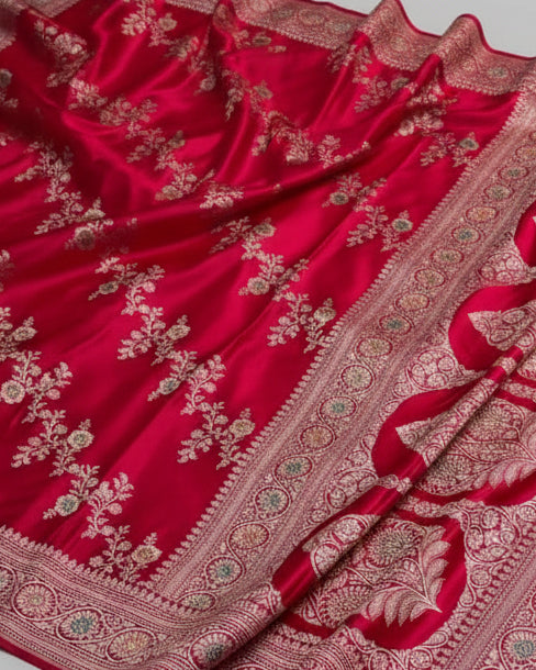 Red fabric with intricate gold and silver embroidery on a white background