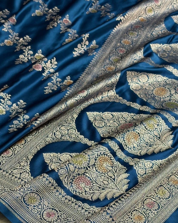 Blue fabric with intricate silver embroidery on a beige background