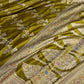 Green saree with intricate gold embroidery on a white background