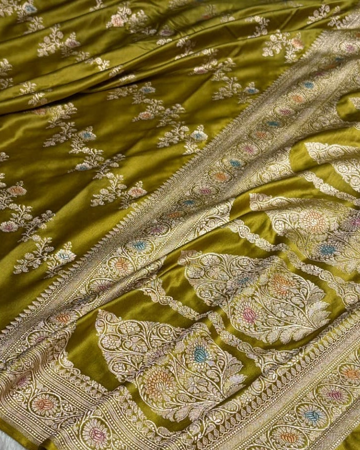 Green saree with intricate gold embroidery on a white background