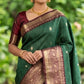 Woman wearing a green saree with a brown border in an outdoor setting